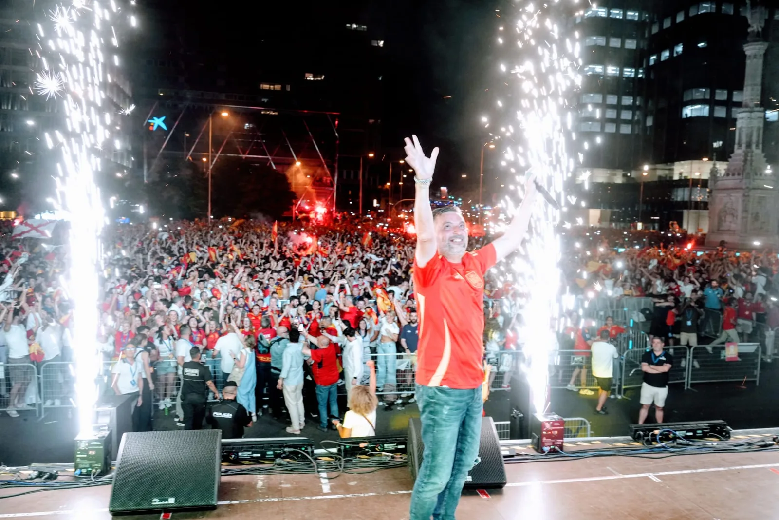Alex Parreño con los brazos en alto en el escenario de Colón entre bengalas